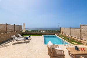 a villa with a swimming pool and a table and chairs at Diamond Star Hotel in Falasarna
