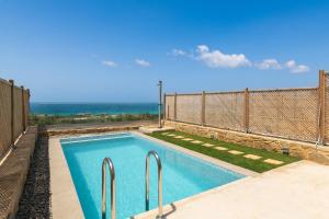 a swimming pool with a fence and a fence at Diamond Star Hotel in Falasarna