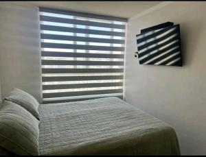 Un dormitorio con una cama y una ventana grande. en Departamento a pasos de Enjoy, en Coquimbo 11 fotos más