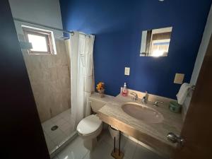 La salle de bains bleue est pourvue d'un lavabo et de toilettes. dans l'établissement Quintas del mar Mazatlán, à Mazatlán