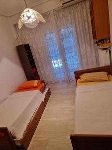a bedroom with two beds and a chandelier at Efchi city center apartment in Katerini