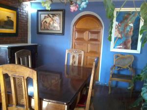 comedor con mesa, sillas y pared azul en Hostal Paris, en Arequipa