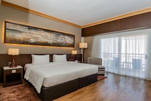 een slaapkamer met een groot bed en een groot raam bij Jpark Island Resort & Waterpark Cebu in Mactan