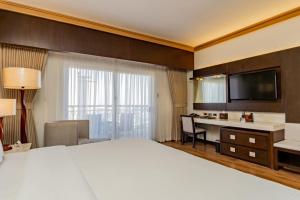 een hotelkamer met een groot bed en een bureau bij Jpark Island Resort & Waterpark Cebu in Mactan