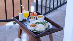 una bandeja de comida con arroz y un vaso de zumo de naranja en Ananthaya -the infinity en Kalutara