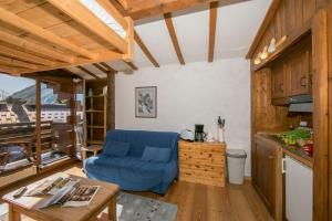 un soggiorno con divano blu in cucina di Résidence Améthystes D12 ski in ski out - Happy Rentals a Chamonix-Mont-Blanc