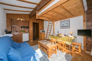 un soggiorno con divano blu e tavolo di Résidence Améthystes D12 ski in ski out - Happy Rentals a Chamonix-Mont-Blanc