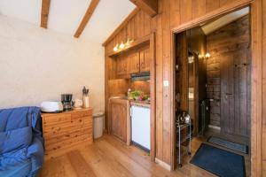 una cucina con armadi in legno e un divano blu in una camera di Résidence Améthystes D12 ski in ski out - Happy Rentals a Chamonix-Mont-Blanc