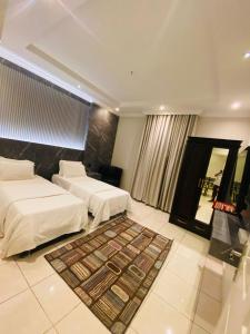 pokój hotelowy z 2 łóżkami i dywanem w obiekcie درر بيروت للوحدات السكنية w mieście Dżudda