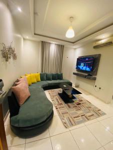 salon z zieloną kanapą i telewizorem w obiekcie درر بيروت للوحدات السكنية w mieście Dżudda