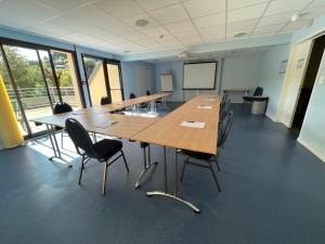 uma grande sala de conferências com uma mesa longa e cadeiras em Hotel Restaurant Le Clos em Besse-et-Saint-Anastaise