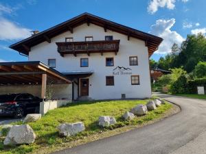 a large white building with rocks in front of it at Ferienwohnungen Kail Thomas in Obsteig