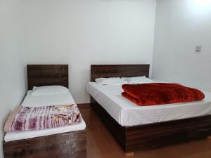 two beds sitting next to each other in a bedroom at Hotel pushpdeep in Phata
