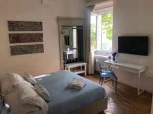 a bedroom with a bed and a desk and a television at B&B Dimor'à in Pitigliano