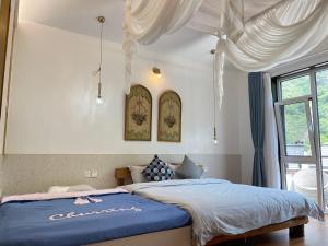 a bedroom with a bed with a blue comforter at Starstay Wuling Mountain B&B in Xinglong
