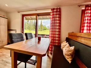 comedor con mesa, sillas y ventana en Gästehaus Alpina, en Krün
