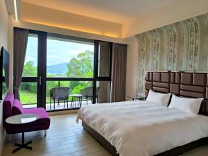- une chambre avec un grand lit et une grande fenêtre dans l'établissement 宜荷山宿, à Datong