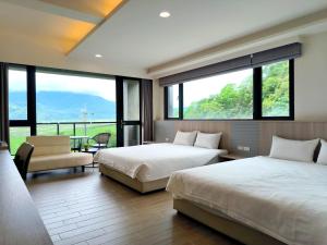 2 camas en una habitación con ventanas grandes en 宜荷山宿 en Datong