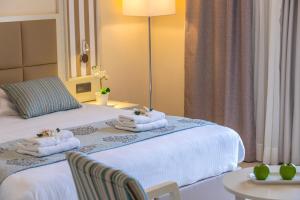 um quarto de hotel com duas camas com toalhas em Aquamare Beach Hotel & Spa em Pafos