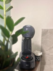 a black coffee maker sitting on a table next to a plant at Apartman Diamond LUX in Surčin