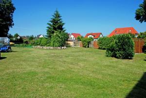 a yard with a group of houses and trees at Ferienhaus am Sund in Altefähr