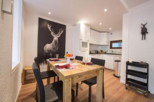 a dining room with a table and a deer painting on the wall at Résidence Androsace 42 Happy Rentals in Chamonix