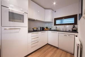 a white kitchen with white cabinets and a window at Résidence Androsace 42 Happy Rentals in Chamonix