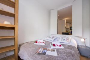 a bedroom with a bed with towels and books at Résidence Androsace 42 Happy Rentals in Chamonix