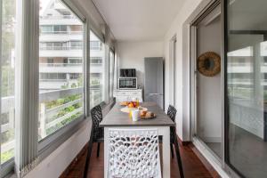 ein Esszimmer mit Tisch und Stühlen und Fenstern in der Unterkunft Port et Centre ville Climatisation Piscine au sein de la résidence Port in La Grande-Motte