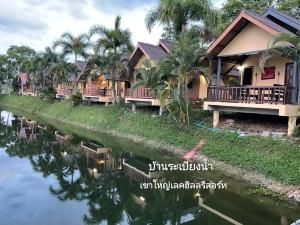 dom obok rzeki z palmami w obiekcie Khao Yai Lake Hill Resort เขาใหญ่เลค ฮิลล์ รีสอร์ท w mieście Khanong Phra