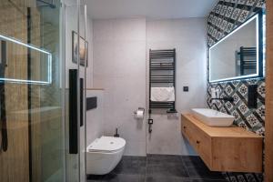 W łazience znajduje się toaleta, umywalka i lustro. w obiekcie Kompleks Antałówka Termy & Med w Zakopanem