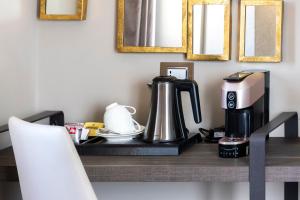 a table with a coffee maker and a coffee pot on it at Milestone in Quartu SantʼElena
