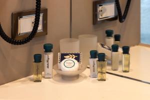 a bathroom counter with bottles of lotion and a mirror at Milestone in Quartu SantʼElena