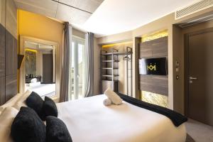 a bedroom with a large white bed with black pillows at Milestone in Quartu SantʼElena