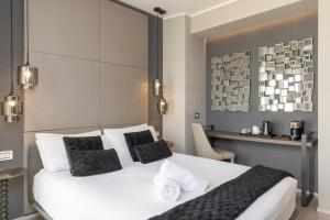 a bedroom with a large white bed with black pillows at Milestone in Quartu SantʼElena