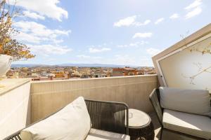 a balcony with a chair and a table and a view at Milestone in Quartu SantʼElena