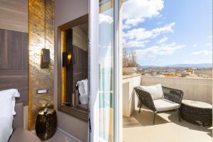 ein Zimmer mit Balkon, mit Stuhl und Fenster in der Unterkunft Milestone in Quartu SantʼElena
