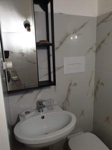 ein weißes Bad mit einem Waschbecken und einem WC in der Unterkunft Casa Sveva in Syrakus