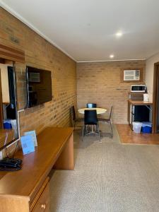 a room with a table and chairs and a brick wall at Quays Motel San Remo in San Remo