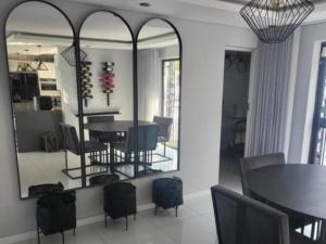 a dining room with a table and chairs and a mirror at DZUVHA BOUTIQUE VILLA in Hartbeespoort