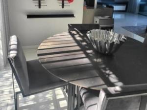 a dining table and chairs with a black table at DZUVHA BOUTIQUE VILLA in Hartbeespoort