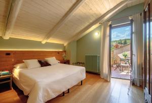 een slaapkamer met een groot bed en een balkon bij La Giolitta Rooms & Apartment in Barolo