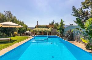 a swimming pool in the backyard of a house at DM Elegant and Charming Villa in Foinikiá