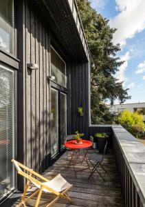 un patio con mesa roja y sillas en un edificio en Kabane 49, en Niort