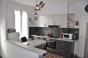 a kitchen with a table and a microwave in it at La maison de Mado in Saint-Ouen
