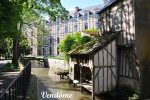 a building next to a river in front of a building at La maison de Mado in Saint-Ouen