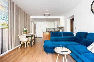 a living room with a blue couch and a table at Apartmány Jako doma in Plzeň