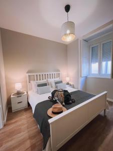 a bedroom with a large bed with a hat on it at Casinha Amarela in Figueira da Foz
