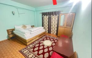 a bedroom with a white bed and a red rug at Dechen Ling Homestay by StayApart in Tabo