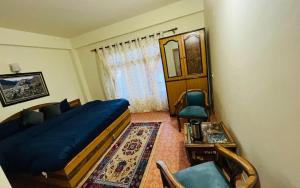 a bedroom with a bed and a table and chairs at Dechen Ling Homestay by StayApart in Tabo